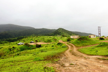 Lush green landscape, trees and foggy mountains in Ayn Khor tourist resort, Salalah, Oman