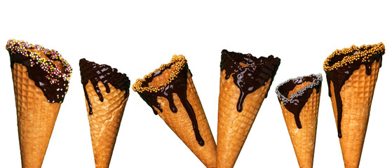 A set of empty wafers cone for ice cream on a white isolated background. Cones dipped in chocolate glaze with sprinkles and toppings perfect for ice cream.