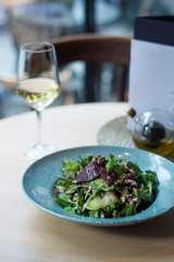 Vegeterian salad on table with wine in restaurant