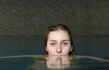 young woman in the water looks into the camera