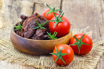 fresh and dried tomatoes on wooden background