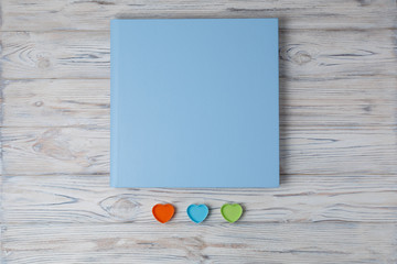 blue photo book with  leather cover.  stylish wedding photo album with space for text.  Beautiful photobook on a wooden background.