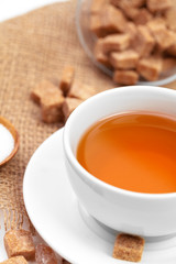 Glass cup of hot tea with sugar on the table