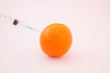 syringue injecting an orange like contaminated food