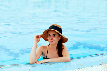 Pool Fashion. Woman In Pool In Summer. Beautiful Fashionable Sexy Girl In Stylish Swimsuit And Trendy Sunglasses Relaxing In Swimming Pool Water On Travel Vacation At Luxury Resort.