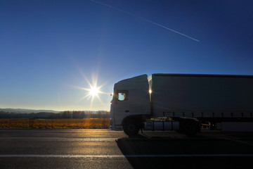 White truck transport on the road at sunset and cargo 