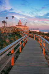 wooden flooring, trail to the lighthouse on the shores of the Atlantic Ocean in the city of Lagos in Portugal On the Sunset