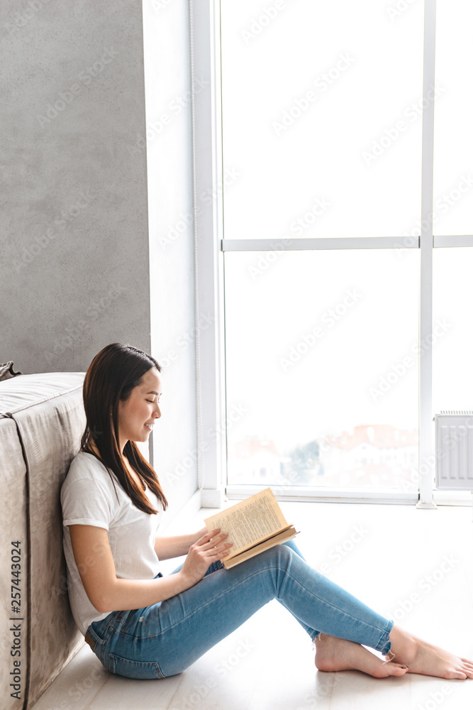 Poster Smiling asian woman reading