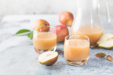 Fresh Pear Juice in a glasses with fresh fruits on light background