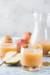 Fresh Pear Juice in a glasses with fresh fruits on light background