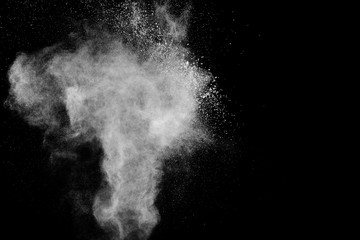 White powder explosion.Freeze motion of white dust particles on black background.