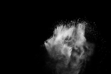 White powder explosion.Freeze motion of white dust particles on black background.