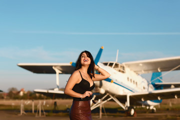 Funny girl portrain standing at airplane. Airplane and woman at sunset. Woman and landing...