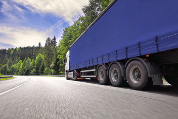 Naklejka na ściany i meble Fast truck transport on the road and cargo