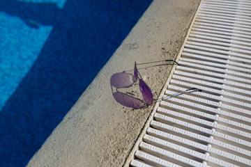 Fototapeta na wymiar Sunglasses lie near the pool closeup