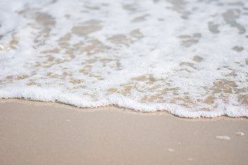 Fototapeta na wymiar beautiful soft wave on sand at the sea sunny day. subject is blurred.