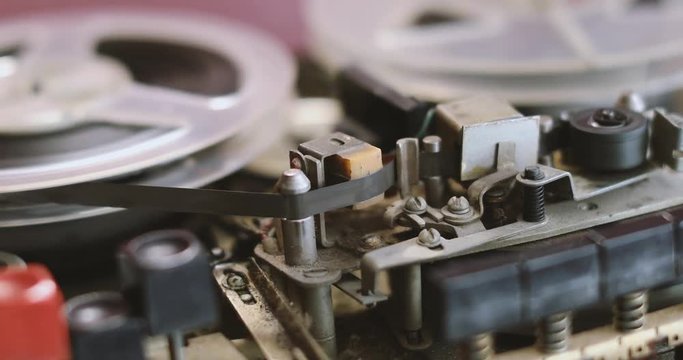 closeup of old reel to reel tape recorder playing music