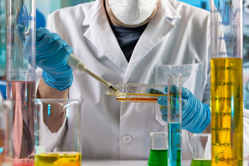 Doctor pipetting sample in cell tissue culture bottle in the research lab / Doctor pipetting sample...