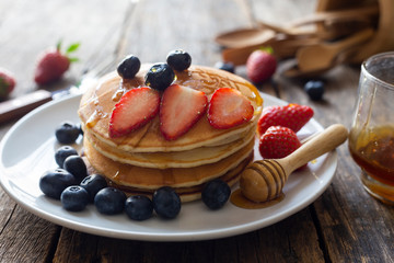 Delicious pancakes with Strawberry and blueberry on wooden table.top view