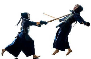 two Kendo martial arts fighters combat fighting in silhouette isolated on white bacground