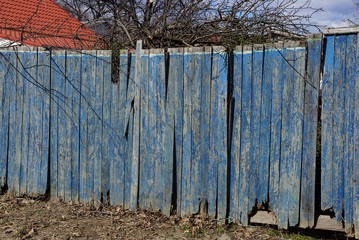 part of blue wooden old fence on rural street