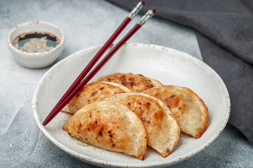 Fried dumplings with meat (beef, pork) or seafood, cabbage and spices in a white plate close-up. ...