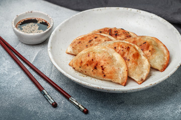 Fried dumplings with meat (beef, pork) or seafood, cabbage and spices in a white plate close-up. ...