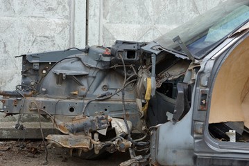 part of the frame of the old black car disassembled on the street