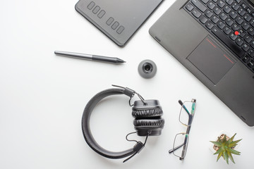 Desktop designer and creative retoucher with a graphics tablet, laptop, glasses. Design, flat lay