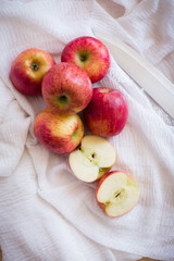 Red apples in a wooden bowl on a wooden background