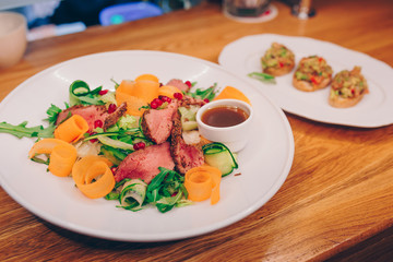 Waiter serving Grilled Skewers chicken fillet meat with baked vegetable pepper apperitive garnish at restaurant, close up view. Selective focus. Design Gourmet and luxury concept service