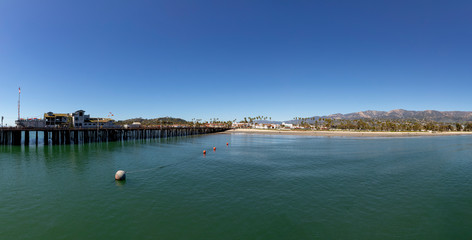 Obraz premium Santa Barbara pier under blue sky with panoramic view of scenic beach with palm trees