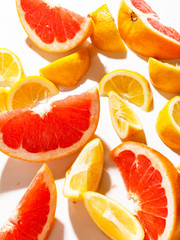 Slices of juicy grapefruit and lemon on white background. Top view.