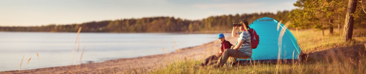 Family resting with tent in nature at sunset