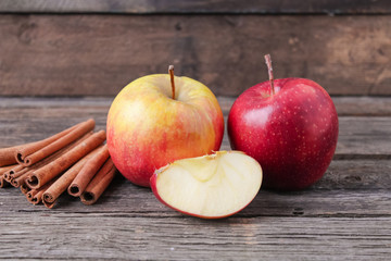 cinnamon sticks and apples on wooden background