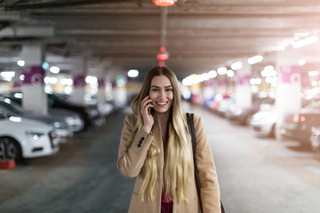 Woman with smart phone in underground parking lot
