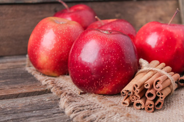 cinnamon sticks and apples on wooden background