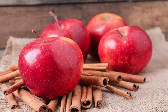 cinnamon sticks and apples on wooden background