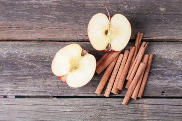 cinnamon sticks and apples on wooden background