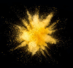 Explosion of golden powder on black background