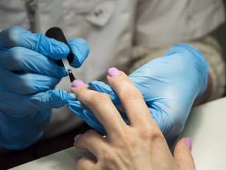 Applying nail Polish in the nail salon. Close up.