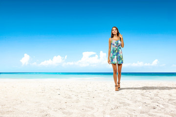 Fototapeta na wymiar Slim young woman on beach and sea landscape 