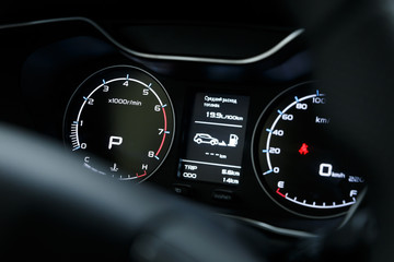 Close-up of a glowing beautiful dashboard of a modern expensive car. The interior of the car. The foreground is blurred