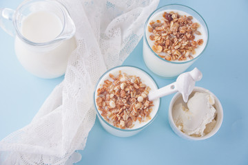 Yogurt in glass, milk and cream cheese on a table with white napkin. Top view.