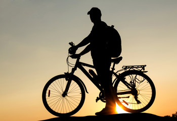Fototapeta na wymiar Concept of healthy lifestyle. Silhouette of cyclists at sunset