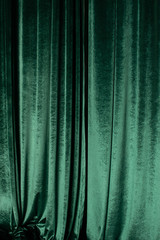 Green curtain of luxurious velvet on the theater stage. Copy space. The concept of music and theatrical art. Concept for a festive performance for St. Patrick's Day, festival, jazz month