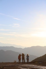 3 friends watching the sunset on mountain top