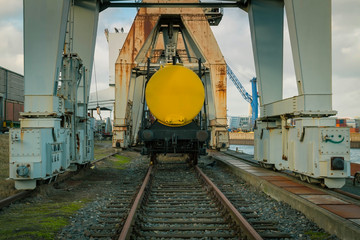 Eisenbahnwaggon auf Schienen mit einem gelben Transportbehälter