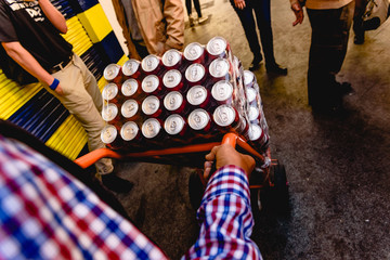 Valencia - Spain, March 16, 2019: Operator transporting many cans of beer for a street party.