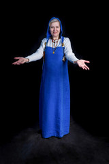 Naklejka premium Mature woman in blue Viking Hangerok dress making welcome gesture